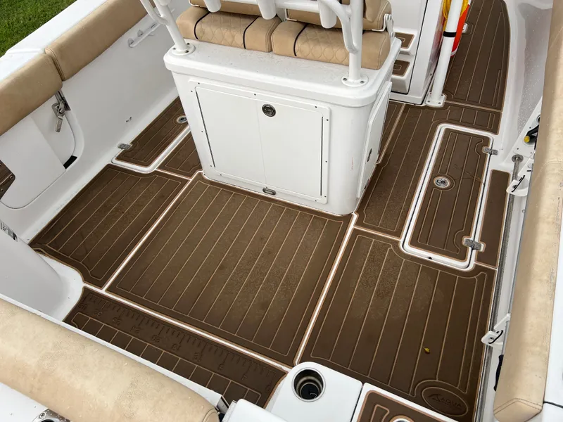 Slide: The Image of The image shows the deck of a 2018 Sportsman Open 252 Center Console boat with brown cushions. - 4