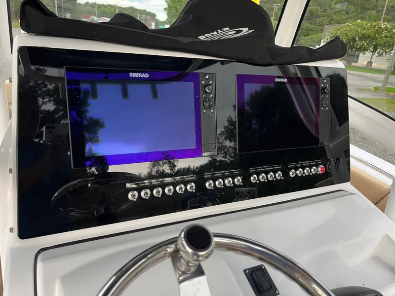 Slide: The Image of The image shows the dashboard of a 2018 Sportsman Open 252 Center Console boat with two Simrad screens. - 11