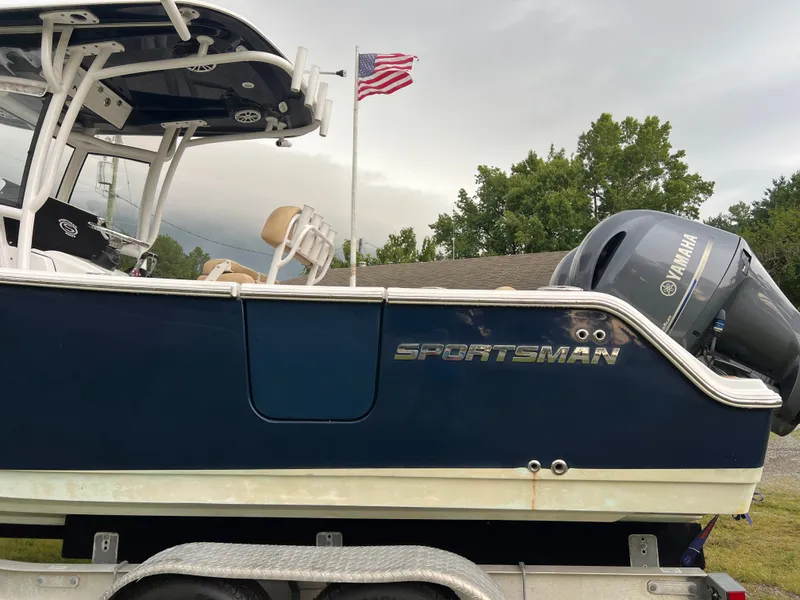 Slide: The Image of A 2018 Sportsman Open 252 Center Console boat on a trailer. It features a Yamaha outboard motor and an American flag in the background. - 2