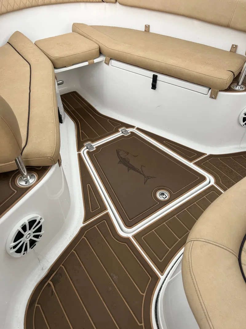 Slide: The Image of The image shows the bow area of a 2018 Sportsman Open 252 Center Console boat with beige cushions and a fish motif on the floor. - 16