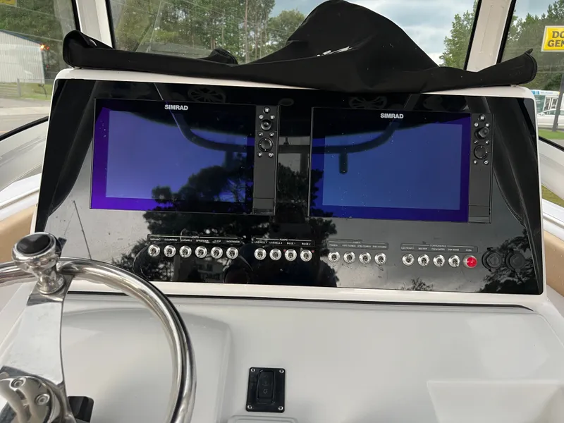 Slide: The Image of The image shows the dashboard of a 2018 Sportsman Open 252 Center Console boat with two Simrad screens. - 10
