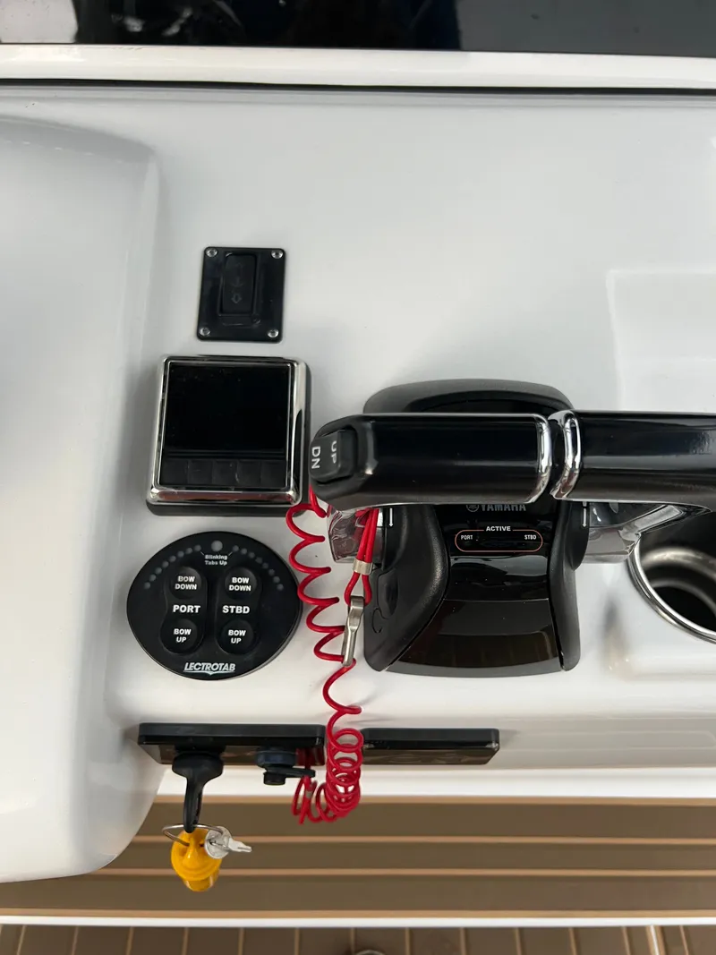 Slide: The Image of Close-up of a Sportsman Open 252 Center Console boat's helm with controls and gauges. - 9