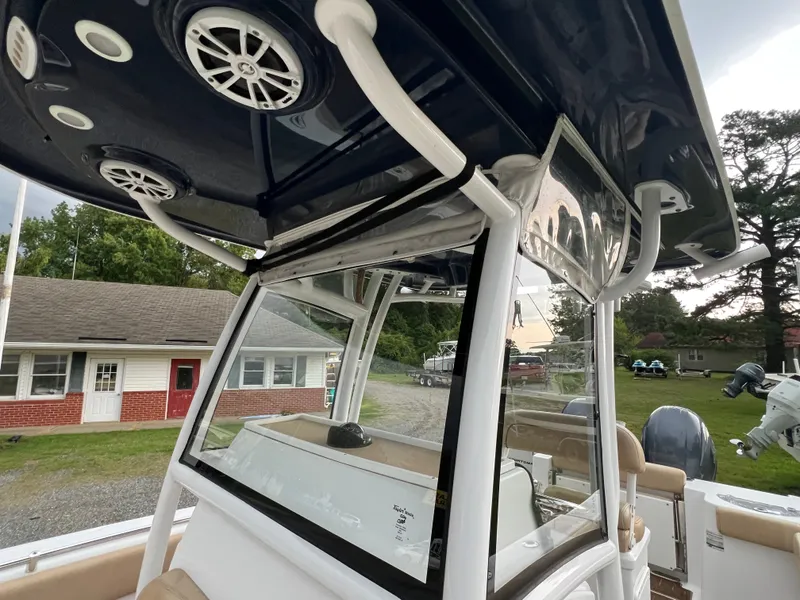 Slide: The Image of The image shows the cockpit of a 2018 Sportsman Open 252 Center Console boat with speakers and helm. - 7
