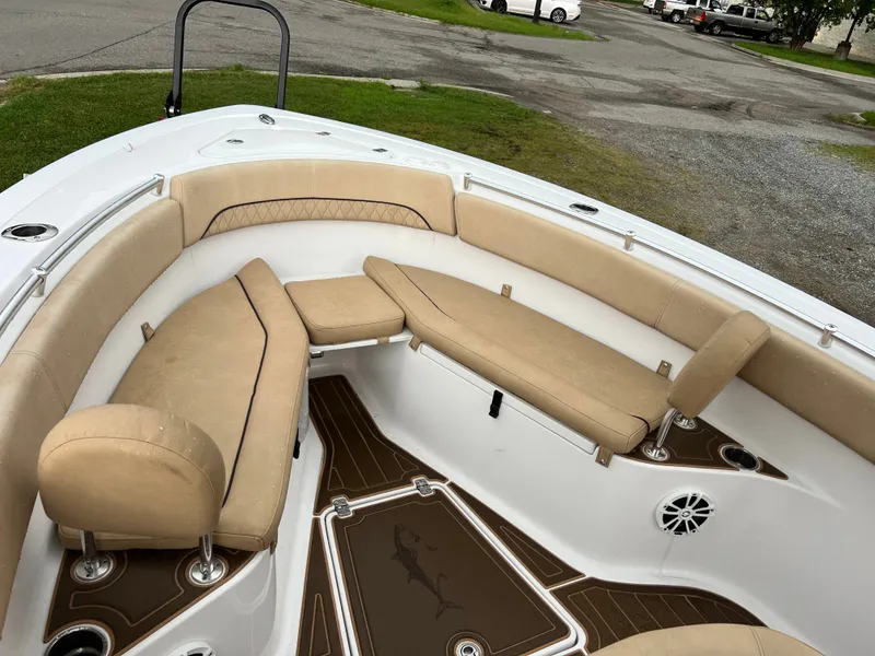 Slide: The Image of The image shows the bow area of a 2018 Sportsman Open 252 Center Console boat with beige upholstery. - 15