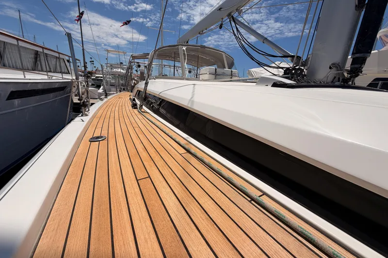 Slide: The Image of 2020 Beneteau Oceanis 51.1 sailboat with teak deck, docked under a clear blue sky. - 22