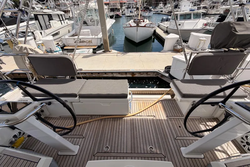Slide: The Image of Beneteau Oceanis 51.1 yacht cockpit with dual steering wheels, docked at marina, 2020 model. - 28