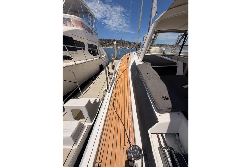Slide: The Image of 2020 Beneteau Oceanis 51.1 yacht with teak deck, docked beside another boat. - 11