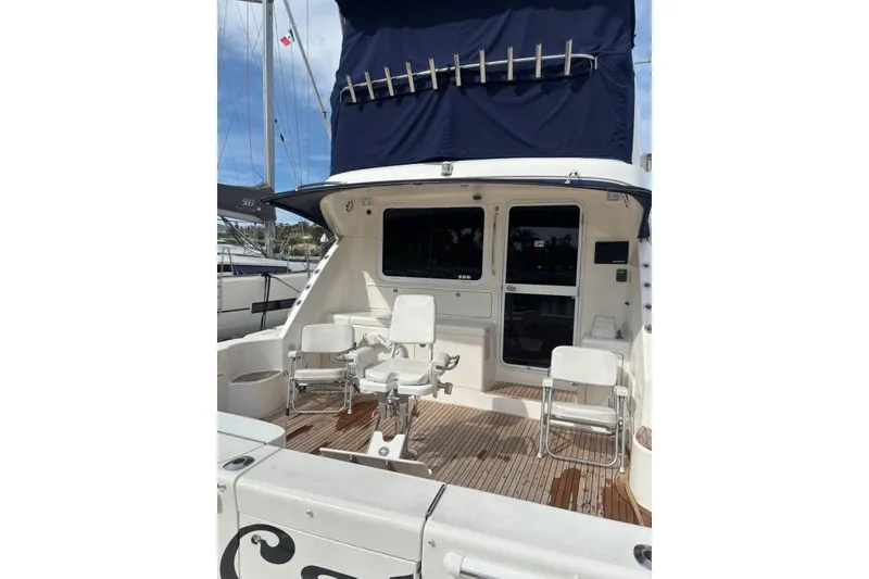 Slide: The Image of 2007 Riviera 51 Enclosed Flybridge yacht with spacious deck and seating area. - 4