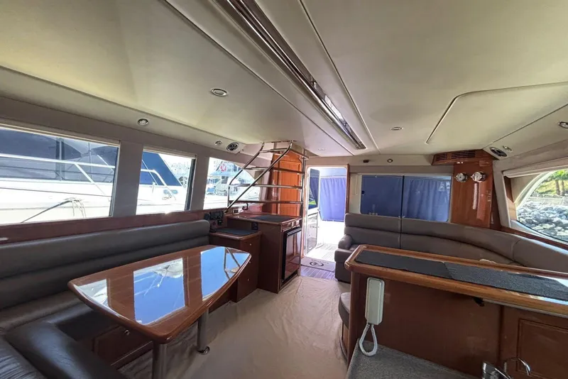 Slide: The Image of Luxurious interior of 2007 Riviera 51 Enclosed Flybridge yacht with elegant seating and dining area. - 12