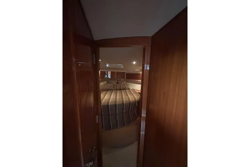 Slide: The Image of Interior view of 2007 Riviera 51 Enclosed Flybridge bedroom with striped bedding. - 16