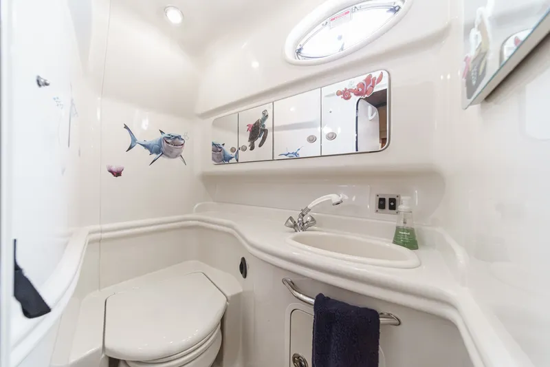 Slide: The Image of The image shows a clean boat bathroom with a sink, toilet, and mirror. - 35