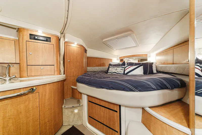 Slide: The Image of The 2006 Sea Ray 340 Sundancer cabin features a cozy bed and wooden cabinetry. - 24