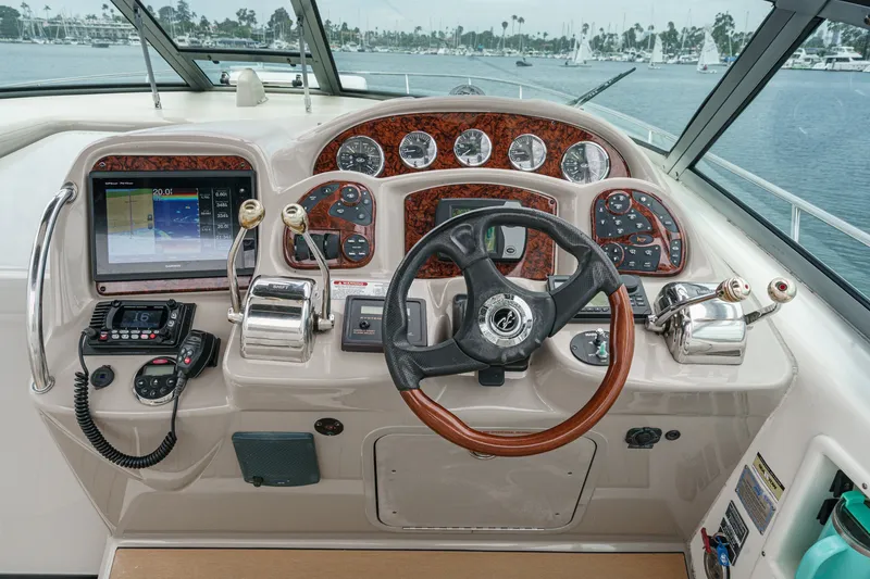 Slide: The Image of The 2006 Sea Ray 340 Sundancer cockpit features an elegant dashboard with wood paneling. - 17