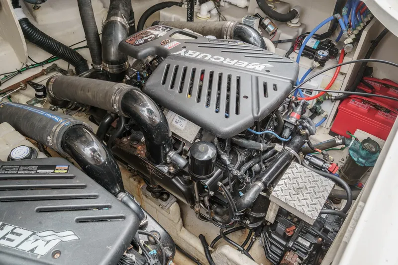 Slide: The Image of The engine room of a 2006 Sea Ray 340 Sundancer with two MerCruiser engines and various hoses and cables. - 37