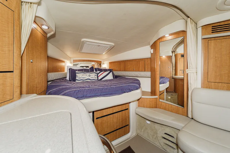 Slide: The Image of The 2006 Sea Ray 340 Sundancer cabin features a cozy bed, wooden cabinetry, and seating area. - 22