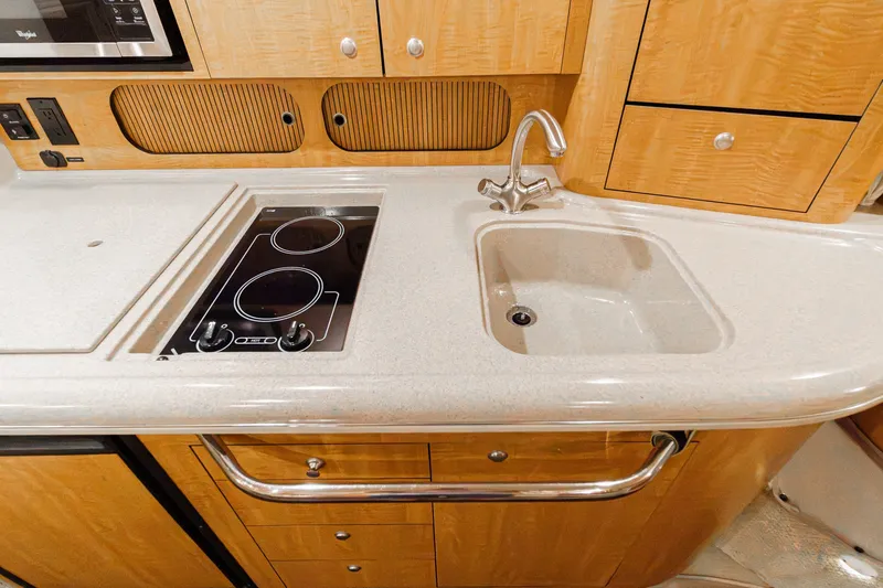 Slide: The Image of The 2006 Sea Ray 340 Sundancer's galley features a cooktop and sink. - 28