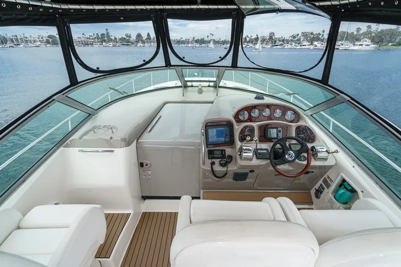 Slide: The Image of The cockpit of a 2006 Sea Ray 340 Sundancer with sleek white seating and a modern helm station. - 15