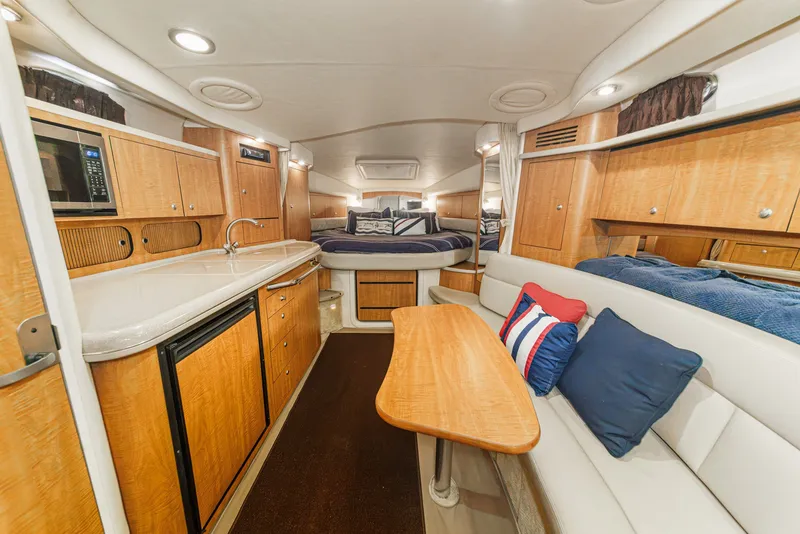 Slide: The Image of The interior cabin of a 2006 Sea Ray 340 Sundancer features a galley, seating area, and sleeping space. - 21