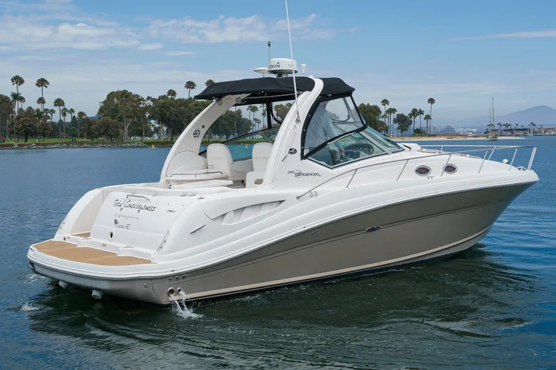 Slide: The Image of A 2006 Sea Ray 340 Sundancer on calm water with palm trees in the background. - 5