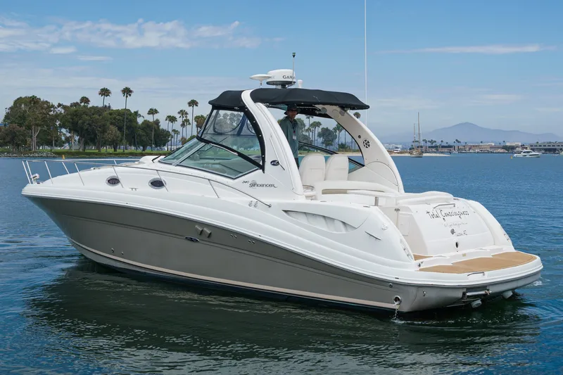 Slide: The Image of A white 2006 Sea Ray 340 Sundancer cruising on calm water. Palms and mountains in the background. - 3