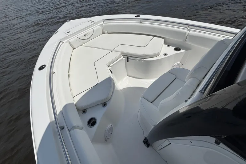 Slide: The Image of 2015 Sea Hunt Ultra 235 SE boat interior with white seating, on calm water. - 7