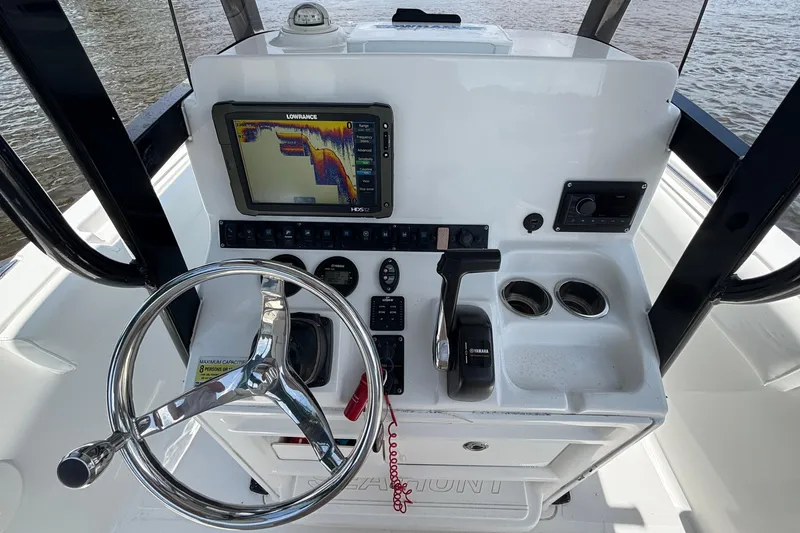 Slide: The Image of 2015 Sea Hunt Ultra 235 SE boat dashboard with steering wheel and navigation display. - 9
