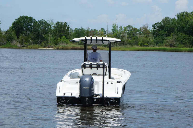 Slide: The Image of 2015 Sea Hunt Ultra 235 SE boat on calm water, rear view with outboard motor. - 21