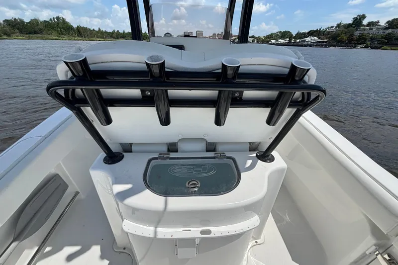 Slide: The Image of 2015 Sea Hunt Ultra 235 SE boat interior with rod holders and storage on a sunny day. - 12