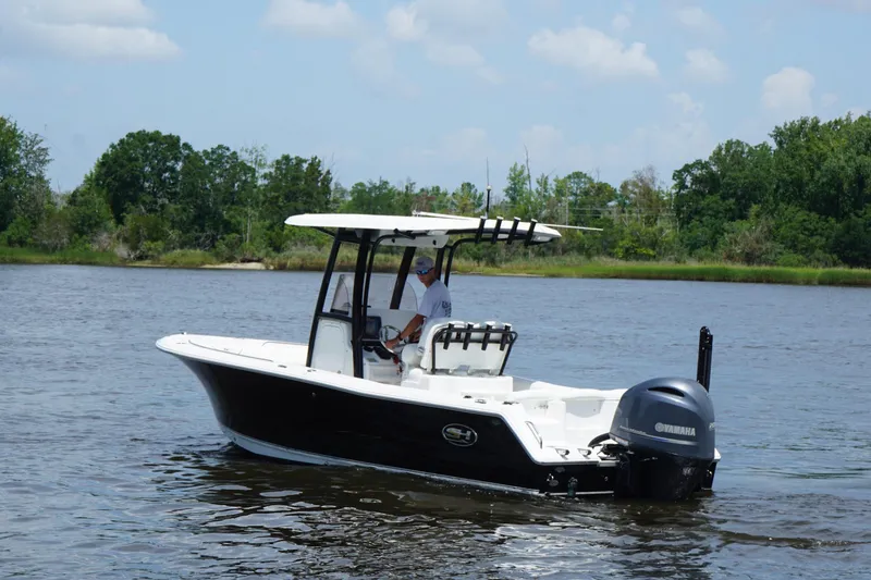 Slide: The Image of 2015 Sea Hunt Ultra 235 SE boat cruising on a calm river under a clear sky. - 20
