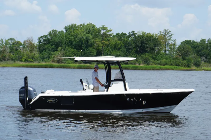 Slide: The Image of 2015 Sea Hunt Ultra 235 SE boat on a calm river with lush green background. - 23