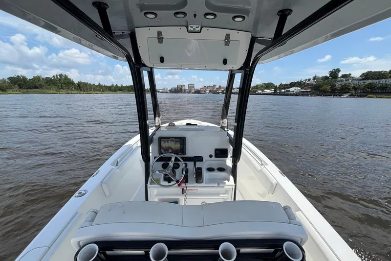 Slide: The Image of 2015 Sea Hunt Ultra 235 SE boat on water, featuring helm and seating area. - 8