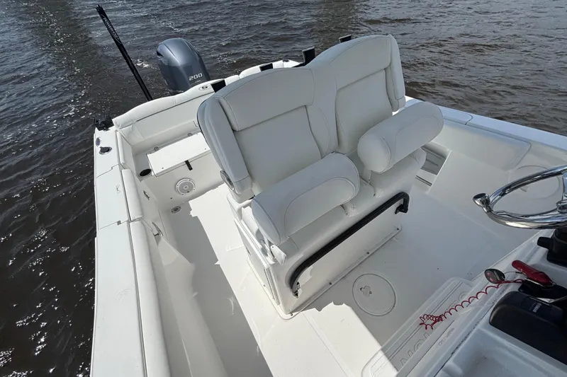 Slide: The Image of 2015 Sea Hunt Ultra 235 SE boat interior with white seating and steering wheel. - 10