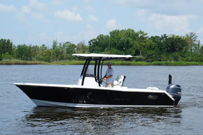Slide: The Image of 2015 Sea Hunt Ultra 235 SE boat cruising on a calm river with lush green shoreline. - 24