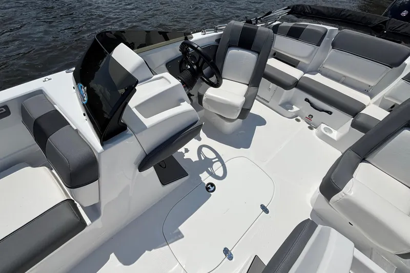 Slide: The Image of 2024 Tahoe T21 boat interior with sleek seating and modern dashboard on the water. - 7
