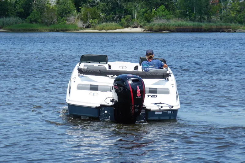 Slide: The Image of 2024 Tahoe T21 boat cruising on a serene lake with lush greenery in the background. - 3