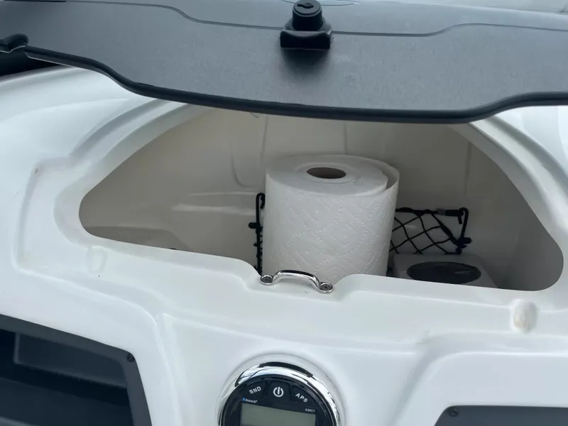 Slide: The Image of An open storage compartment in a boat with a paper towel roll and a net. - 21