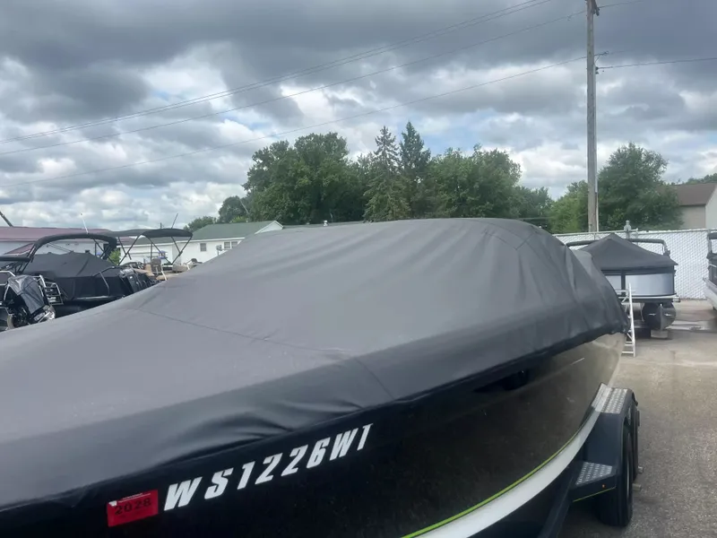 Slide: The Image of A 2018 Tracker TAHOE 700 MOK boat with a cover, parked on a trailer. - 4