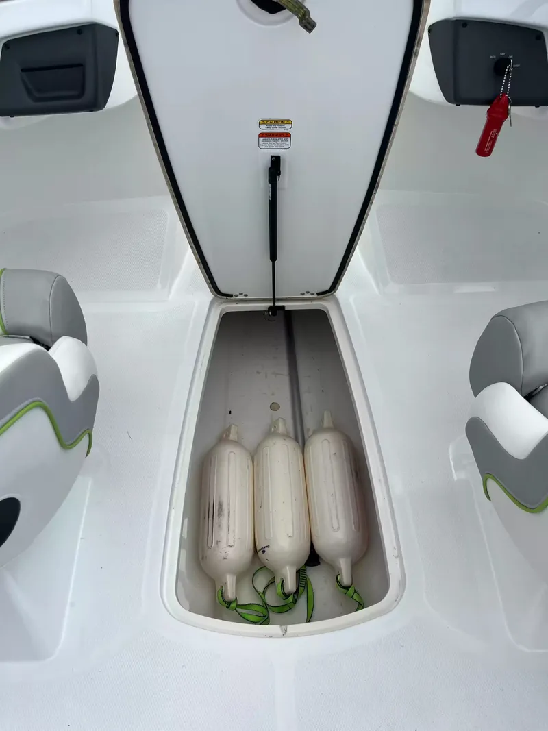 Slide: The Image of The image shows the storage compartment of a 2018 Tracker TAHOE 700 MOK boat with three fenders. - 9