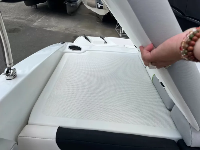 Slide: The Image of A person lifts a cushion on a white boat seat, revealing storage space underneath. - 8