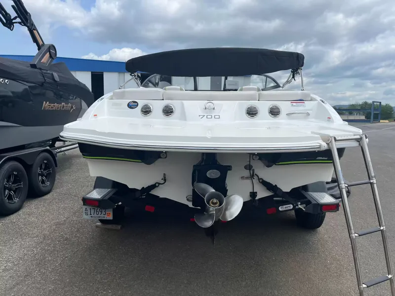 Slide: The Image of The image shows the rear of a white 2018 Tracker TAHOE 700 MOK boat with a ladder. - 10