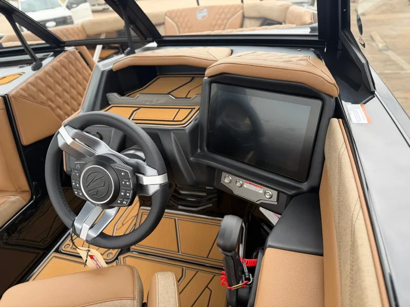 Slide: The Image of The image shows the cockpit of a 2027 Tigé 24RZX boat with a modern steering wheel and large display. - 18