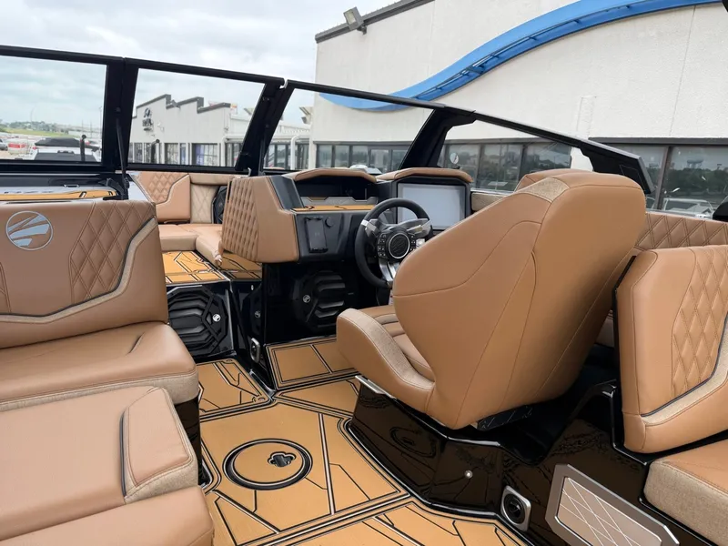 Slide: The Image of The image shows the interior of a 2027 Tigé 24RZX with luxurious brown leather seating and a modern helm. - 15