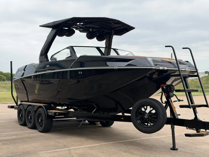 Slide: The Image of A sleek, black Tigé 24RZX boat from 2027 on a trailer, ready for the water. - 6