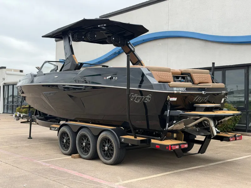 Slide: The Image of A sleek, black Tigé 24RZX boat from 2027 sits on a trailer. It features a modern design. - 3