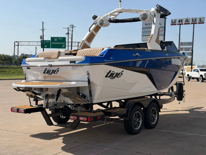 Slide: The Image of A modern 2027 Tigé Z1 on a trailer, featuring blue and white paint and speakers. - 5