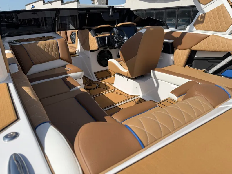 Slide: The Image of The image shows the interior of a 2027 Tigé Z1 boat with luxurious brown upholstery. - 12