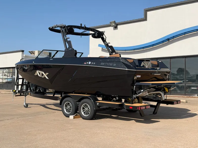 Slide: The Image of A black ATX Surf Boat, model 22 Type-S, is on a trailer in front of a building. - 3