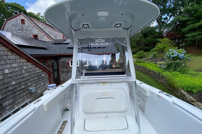 Slide: The Image of 2018 Sportsman Open 242 Center Console boat with seating, near a house and garden. - 30