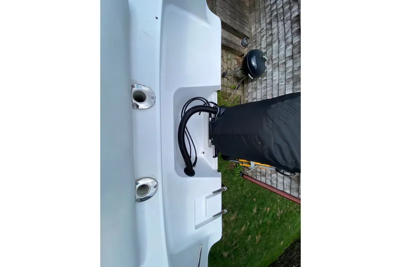 Slide: The Image of 2018 Sportsman Open 242 Center Console boat stern with covered engine and rod holders. - 24