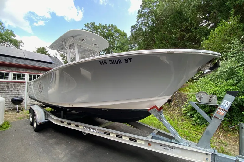 Slide: The Image of 2018 Sportsman Open 242 Center Console boat on trailer, parked outdoors. - 1